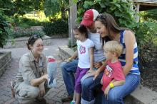 an Omaha Zoo docent shows a parrot to a family