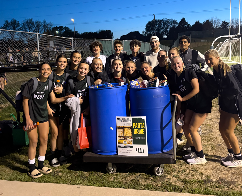 Millard West Girls Soccer team stands next to barrels of pasta collected for Heartland Hope Mission