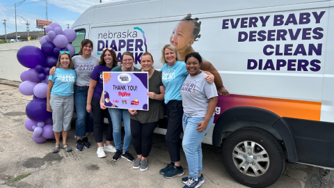 Nebraska Diaper Bank staff in front of their diaper van with celebratory balloons